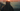 A cinematic sunset scene with a silhouetted person in profile wearing a beanie, with text overlay reading 'Film Burn - Bulb Flicker - Transition - Warm Wash' and a small color swatch box on the left.