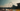 A sepia-toned cityscape photograph featuring the London Eye and riverfront, with a large orange text overlay reading 'Transition - Filmic Elements + Quick Flash!' at the bottom.
